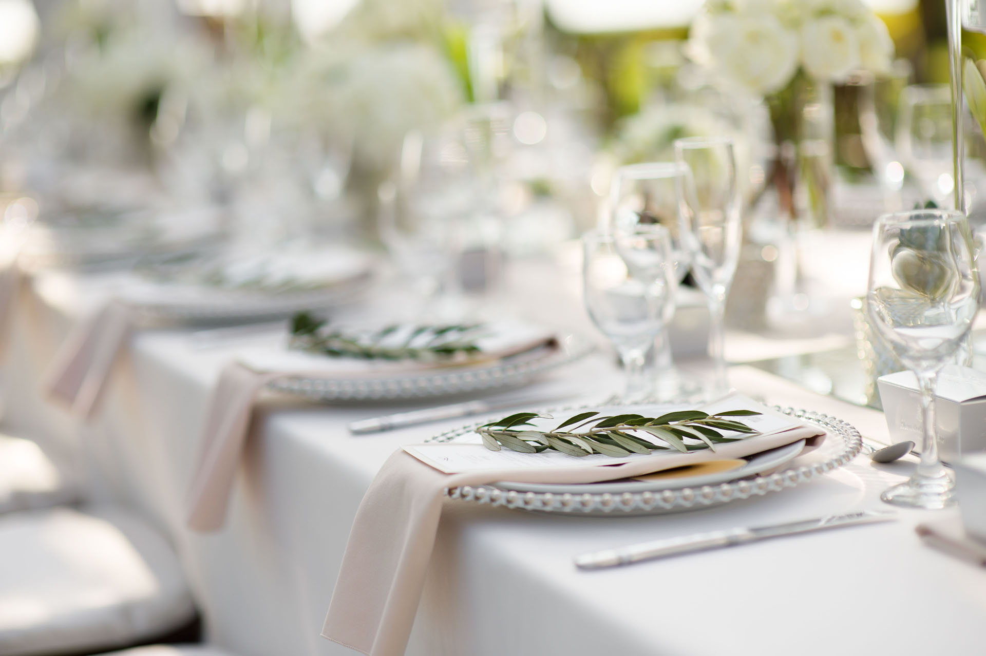 Greenery, glassware and layered place settings at a Turtle Bay wedding reception